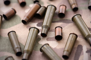 Obraz premium Big amount of shells cartridges from assault rifle bullets on old camouflage fabric