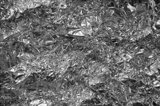 Processed collage of shiny metal silver gray foil crumpled packaging material texture