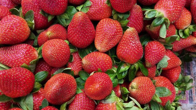 Ripe juicy strawberries stacked neatly in a fruit shop, vibrant red and fresh, perfect for healthy eating, organic lifestyle, vegan diet, and natural food lovers in a colorful market scene
