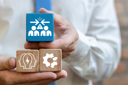 Concept of conflict of interest. Business person holding wooden blocks with icons symbolizing the concept conflict of interest.