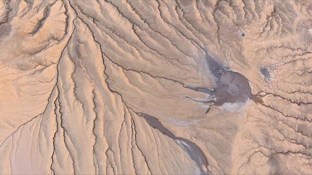 Aerial view of Vulcanii Noroiosi Paclele Mici mud volcanoes with intricate erosion channels and dry soil textures in Scortoasa, Buzau County, Romania.