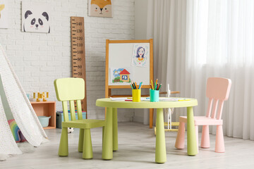 Table with chairs and blackboard in children's room © Pixel-Shot