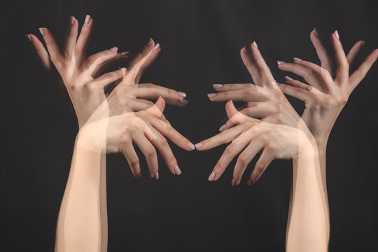 Stroboscopic photo of moving female hands on dark background