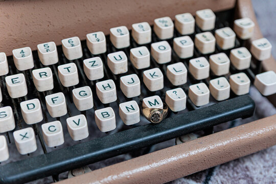 Vintage Typewriter Closeup With Gold Signet Ring On Keys Evoking Retro Writing Nostalgia