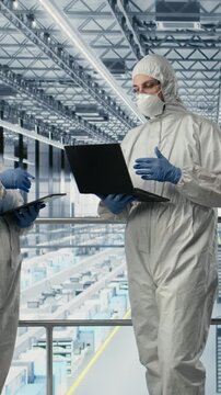 Vertical video Engineering team reviewing semiconductors smart factory schematics, brainstorming. Technicians working together, overseeing hardware layouts using EDA software in industry 4.0 plant