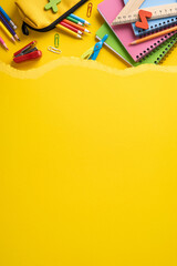 Obraz premium Colorful vertical back to school supplies arranged on a yellow torn paper background with copy space