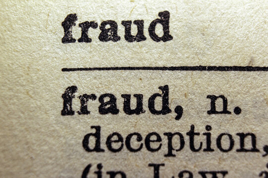 Word fraud printed on dictionary page, macro close up