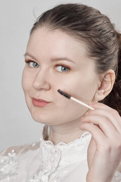 Lash and brow styling concept with mascara spoolie brush in female portrait woman