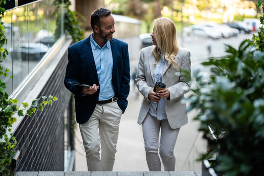 Business colleagues walking and talking casually outdoors