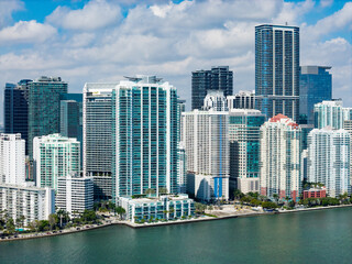 Obraz premium Miami Brickell skyline with skyscrapers and bay view. Miami aerial cityscape with skyline and waterfront. Miami coastal skyline with blue sky clouds. Miami skyline with modern architecture towers.
