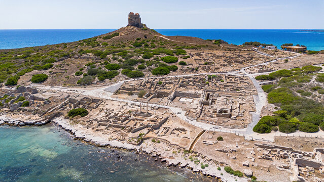 Aerial view of the ancient archaeological site of Tharros with Roman columns and ruins overlooking the sea, Sinis peninsula, Sardinia, Italy