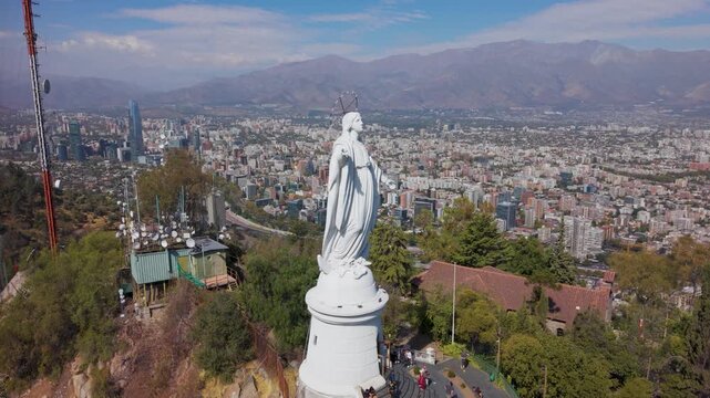 Drone orbiting counter-clockwise around the Virgin Mary statue on San Crist&oacute;bal Hill, showcasing the urban sprawl of Santiago and the Andes