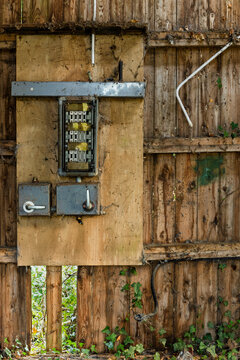 Old electrical fuse box on wooden wall in abandoned building