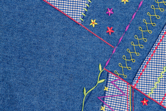 Colorful embroidery on denim fabric showing different stitches and patterns in a craft project at a sewing workshop during daytime