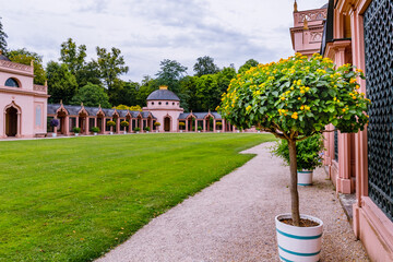 Obraz premium Beautiful garden with colorful trees and small buildings under a cloudy sky