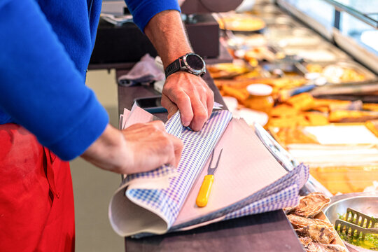 Man wraps food at a market stall in the afternoon while preparing for customers at a food shop