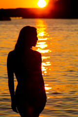 Fototapeta premium Sunset Serenity: A Captivating Silhouette of Beauty and Grace in Tranquil Waters