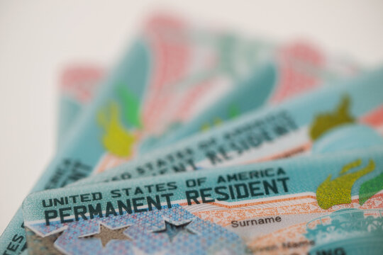 Close-up view of United States Permanent Resident cards stacked together. Concept of immigration, residency status, identity documentation, and legal authorization to live and work in the USA.