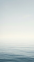 Obraz premium A vast, pale blue and white seascape meeting a muted sky, creating an expansive, peaceful horizon for meditation and quiet thought, light, peace, abstract