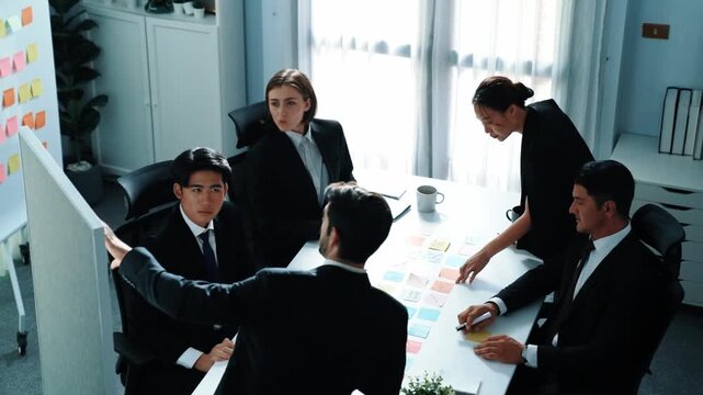 Top view of businessman explain marketing strategy and choose idea by using colorful stick notes. Professional marketing team brainstorming and planning financial plan at meeting room. Directorate.