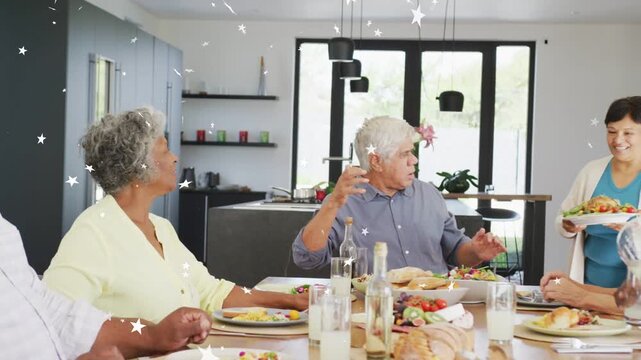 Server bringing platter group passing plates pouring water stars drifting over table sharing food
