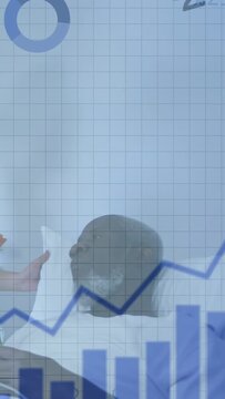 Vertical video: Senior man in bed tracking nurse hand moving charts appearing analysing health data