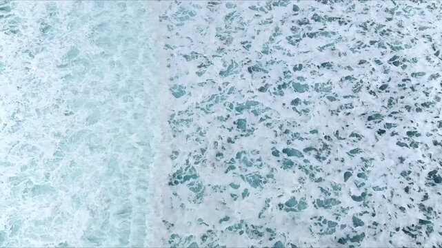 Aerial view of churning turquoise sea water with white foam and crashing waves Nordland, Norway.