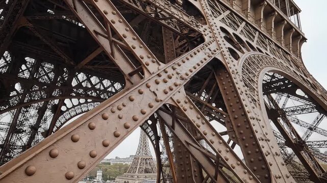 Closeup of the intricate iron lattice structure of the Eiffel Tower in Paris.