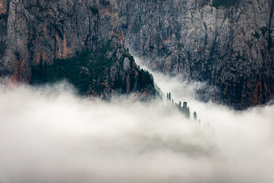 Misty mountain landscapes of Zhagana in Gansu, China, with dramatic clouds, alpine villages and rugged peaks emerging through fog.
