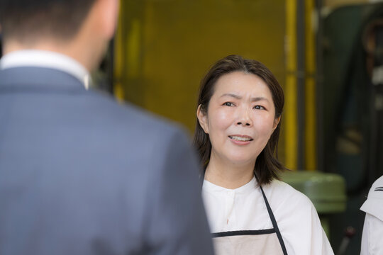 工場で来客対応する女性作業員のポートレート町工場ビジネスシーン　これって飛び込み営業？忙しいのに&hellip;