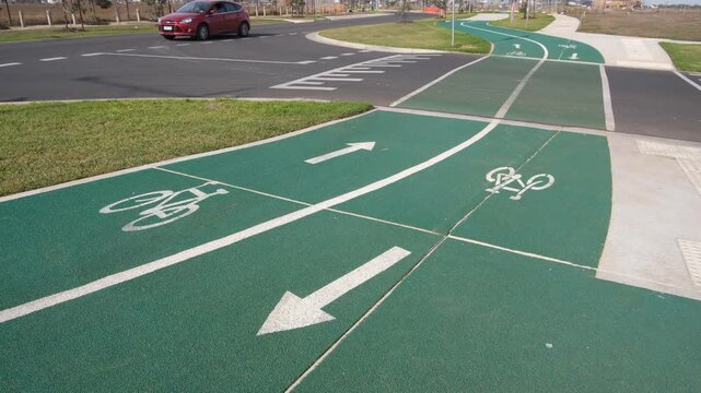 A newly constructed and painted shared bicycle and pedestrian path at a road intersection in a suburban road in Tarneit, Melbourne, Australia.&nbsp;Directional arrows, bicycle symbols are marked on surface