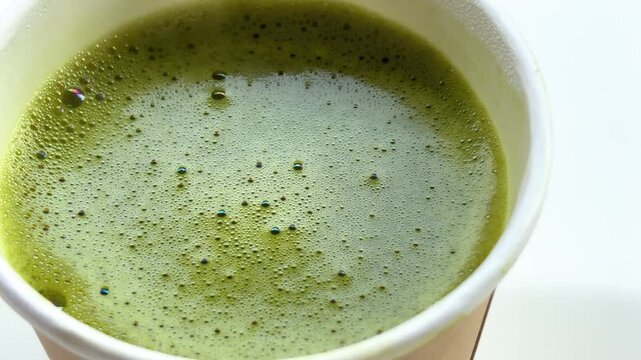 Overhead Shot of Fresh Organic Matcha Green Tea Latte with Creamy Foam in Sustainable Paper Cup