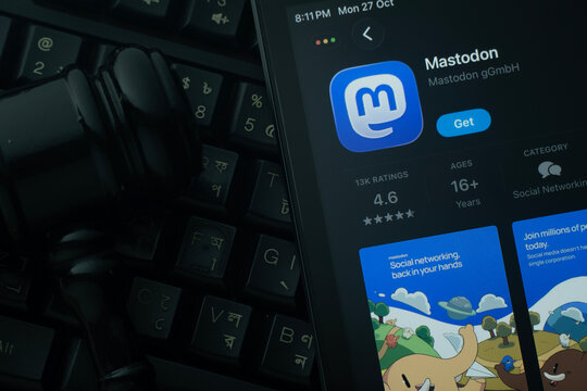Dhaka, Bangladesh- 28 Oct 2025: An iPad displaying the Mastodon app against a judge's gavel and dark keyboard background.