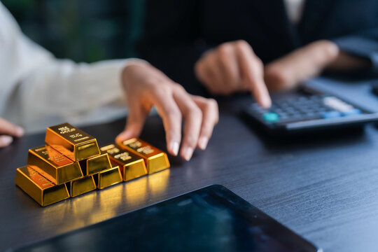 Asian businesswoman holding gold bar for investment trading and wealth management business success and financial growth through gold investment