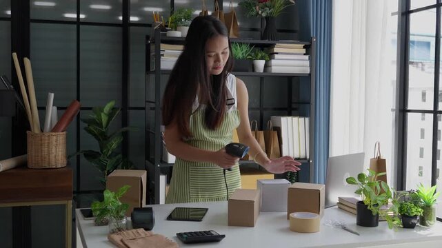 Asian woman using barcode reader checking product