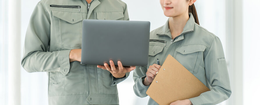 Male and female staff members having a meeting at a factory, warehouse, or logistics center.