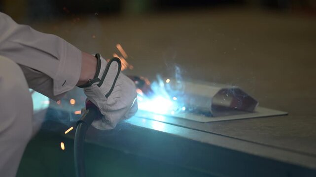 製造業の工場で火花散るアーク溶接、金属加工の手元のクローズアップ工業技術背景素材の動画 スローモーション