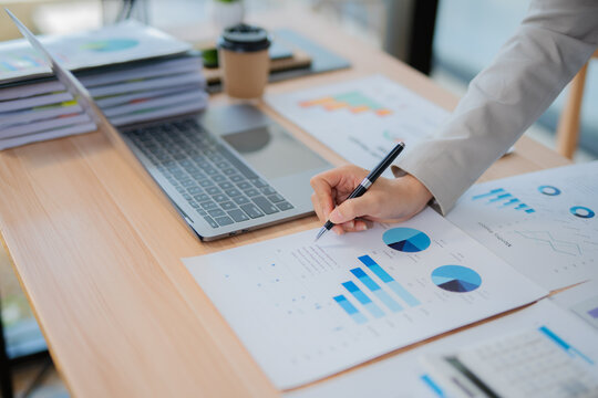 Accountant woman working on financial investment on calculator, calculation, business growth analysis and marketing on graph at office.