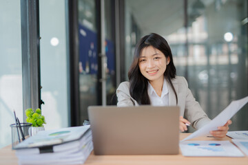 Obraz premium Accountant woman working on financial investment on calculator, calculation, business growth analysis and marketing on graph at office.