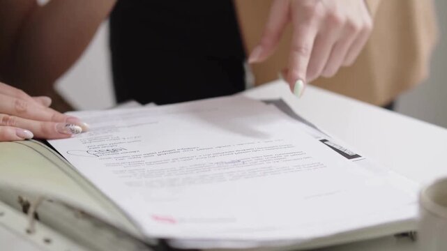 Close-up of two women reviewing a document, with one pointing to a specific section.