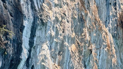 Fototapeta premium Detailed view of spectacular towering limestone walls in Khao Sok. These breathtaking Avatar-style cliffs represent a thrilling and exotic geological wonder in a majestic Thai landscape.