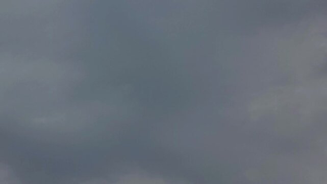 Clouds moving through a dark and overcast sky during a stormy afternoon with dramatic lighting 4K video (Ultra High Definition)