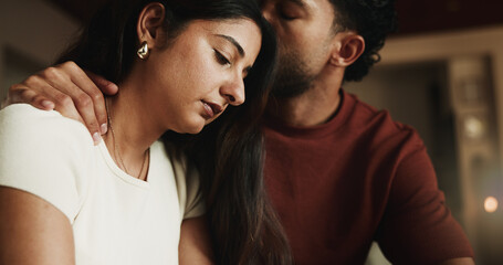 Fototapeta premium Kiss, couple and sad woman with comfort in home, compassion and emotional security for understanding. Empathy, unhappy person and partner with affection for support, console and love for relationship
