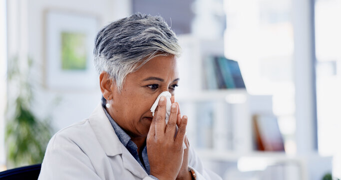 Sick, tissue and doctor blowing nose in office with cold, flu or sinus infection at hospital. Virus, person and mature female healthcare worker with toilet paper for sneeze with allergies or hayfever