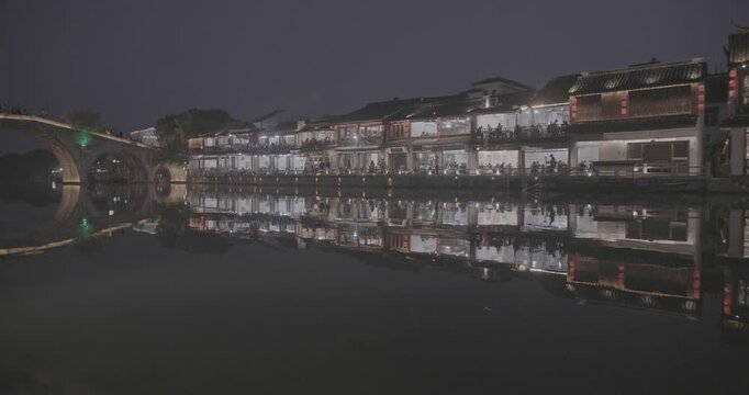 Historic Arched Bridge Over Waterway Reflecting City Lights at Night. Zhujiajiao, Shanghai, China