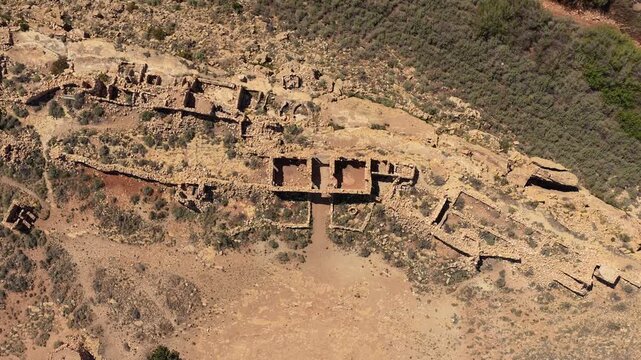 This drone birds eye perspective captures the unique layout of historical cowboy era ruins. The vertical angle provides a clear look at the decaying stone architecture and sunbaked desert textures.