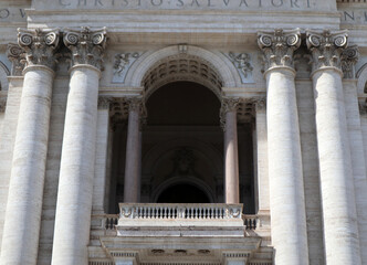 Obraz premium Dettaglio della loggia centrale e delle colonne corinzie della facciata di San Giovanni in Laterano a Roma, maestosa architettura tardo barocca con capitelli decorati e balaustra in marmo