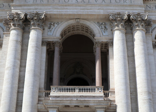Dettaglio della loggia centrale e delle colonne corinzie della facciata di San Giovanni in Laterano a Roma, maestosa architettura tardo barocca con capitelli decorati e balaustra in marmo