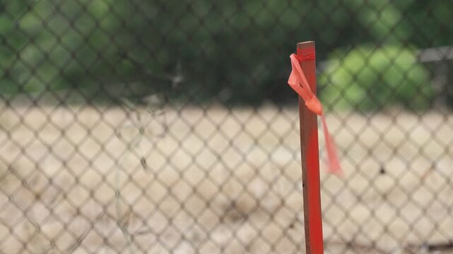 Orange Marker Stick With Ribbon Blowing In Wind