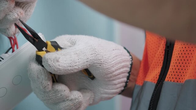 Technician uses pliers to installing modern switch, touch or smart phone-controlled on-off light, Smart Home.